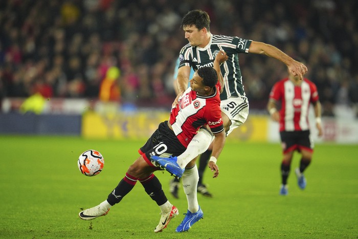 Manchester Uniteds Harry Maguire, right, challenges for the ball with Sheffield Uniteds Cameron Archer during the English Premier League soccer match between Sheffield United and Manchester United at Bramall Lane in Sheffield, England, Saturday, Oct. 21, 2023. (AP Photo/Jon Super)