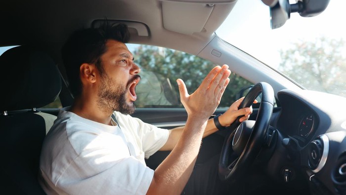 Ilustrasi Pengendara Mobil Marah-marah. Angry screaming male driver driving car. Driving seminar and fear of traffic car traffic concept penyebab kendaraan tersendat