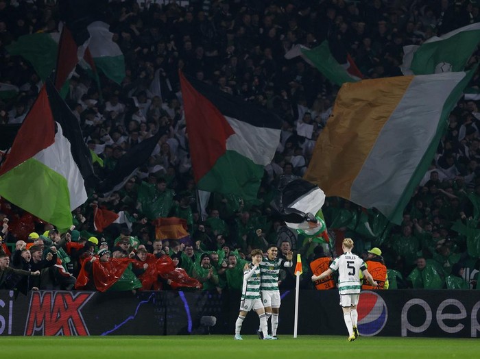 Soccer Football - Champions League - Group E - Celtic v Atletico Madrid - Celtic Park, Glasgow, Scotland, Britain - October 25, 2023 Celtic's Kyogo Furuhashi celebrates scoring their first goal with teammates as Celtic fans wave flags in support of Palestine amid the ongoing conflict between Israel and the Palestinian Islamist group Hamas Action Images via Reuters/Jason Cairnduff