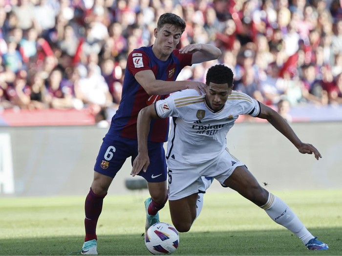 Barcelonas Gavi, left, challenges for the ball with Real Madrids Jude Bellingham during the La Liga soccer match between Barcelona and Real Madrid at the Olympic Stadium in Barcelona, Spain, Saturday, Oct. 28, 2023. (AP Photo/Joan Monfort)