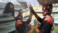 Sejumlah pekerja membersihkan tudung pada bangku pemain cadangan di Stadion Gelora Bung Tomo. 