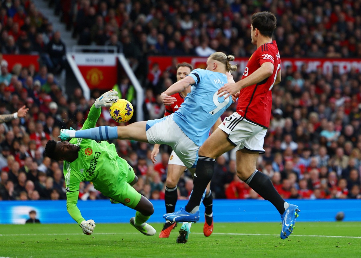 Andre Onana (kiri) berjibaku menahan upaya Erling Haaland mencetak gol. Foto: REUTERS/MOLLY DARLINGTON