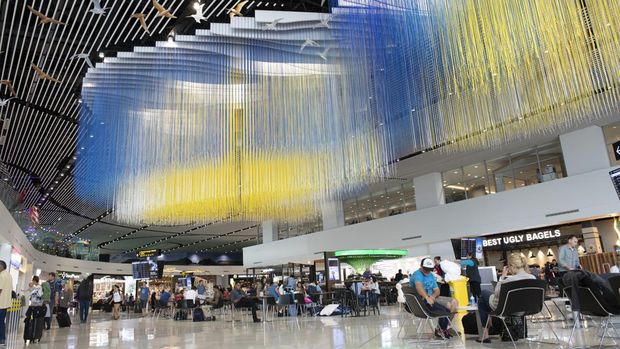 Auckland, New Zealand - December 30, 2018. Passengers walking or resting on chairs in the terminal of Auckland International Airport, New Zealand.