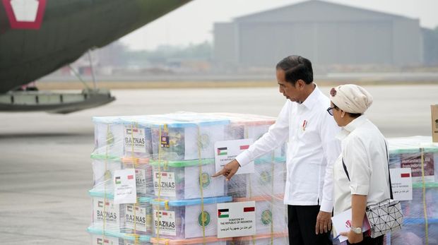 Indonesian President Joko Widodo, left, and Foreign Minister Retno Marsudi look at relief supplies during the inspection of aids for Palestinians in Gaza, before its departure at Halim Perdanakusuma air base in Jakarta, Indo;;nesia, Saturday, Nov. 4, 2023. (AP Photo/Achmad Ibrahim)