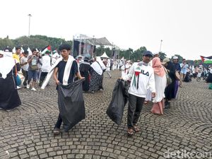 Massa Pungut Sampah di Monas Usai Aksi Damai Bela Palestina Massa Pungut Sampah di Monas Usai Aksi Damai Bela Palestina