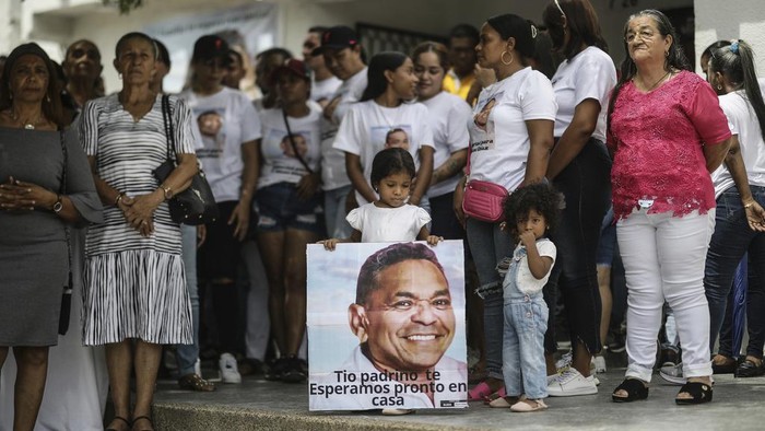 A girl holds a sign that reads in Spanish 