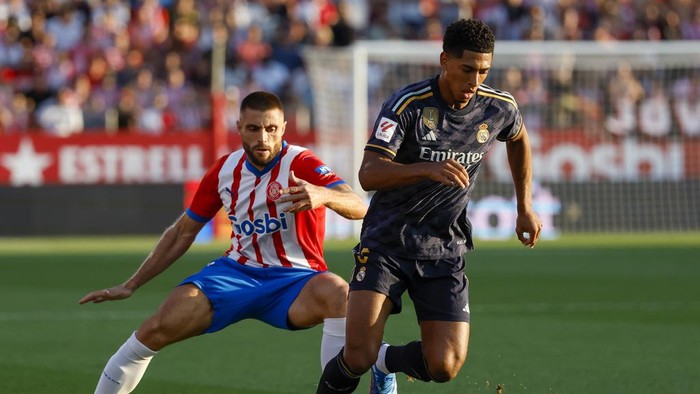 Gironas David Lopez, left, duels for the ball with Real Madrids Jude Bellingham during a Spanish La Liga soccer match between Girona and Real Madrid, at the Montilivi stadium in Girona, Spain, Saturday, Sept. 30, 2023. (AP Photo/Joan Monfort)