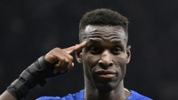 Gaya tunjuk kening itu dipamerkan Nicolas Jackson usai mencetak gol keduanya di dalam laga, alias gol ketiga Chelsea, di menit-menit akhir. Foto: REUTERS/TONY OBRIEN