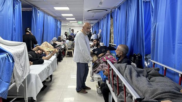 Pasien dan pengungsi internal difoto di rumah sakit Al-Shifa di Kota Gaza pada 10 November 2023, di tengah pertempuran yang sedang berlangsung antara Israel dan gerakan Hamas Palestina.  Pertempuran sengit terjadi di dekat rumah sakit Al-Shifa, dan Israel mengatakan pihaknya telah membunuh puluhan militan dan menghancurkan sebuah terowongan yang merupakan kunci kemampuan Hamas untuk berperang.  Israel melancarkan serangan di Gaza setelah pejuang Hamas melintasi perbatasan militer pada 7 Oktober, menewaskan 1.400 orang, sebagian besar warga sipil, dan menyandera sekitar 240 orang.  (Foto oleh Khader Al Zanoun / AFP)
