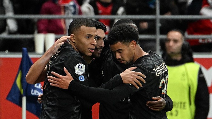 Paris Saint-Germains French forward #07 Kylian Mbappe celebrates with Paris Saint-Germains French midfielder #33 Warren Zaire-Emery (R) and teammates after scoring his teams second goal during the French L1 football match between Stade de Reims and Paris Saint-Germain (PSG) at Stade Auguste-Delaune in Reims, northern France on November 11, 2023. (Photo by FRANCOIS NASCIMBENI / AFP)