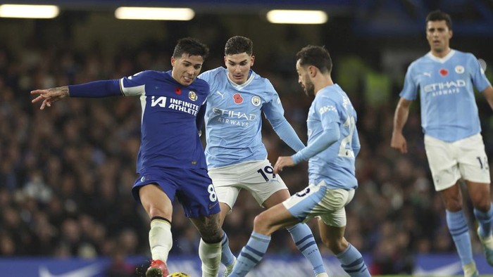 Chelseas Enzo Fernandez, left, challenges for the ball with Manchester Citys Julian Alvarez, centre, and Manchester Citys Bernardo Silva during the English Premier League soccer match between Chelsea and Manchester City at Stamford Bridge stadium in London, Sunday, Nov. 12, 2023. (AP Photo/Ian Walton)