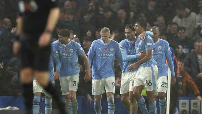 Manchester City players celebrate after Manchester Citys Rodrigo scored his sides fourth goal during the English Premier League soccer match between Chelsea and Manchester City at Stamford Bridge stadium in London, Sunday, Nov. 12, 2023. (AP Photo/Ian Walton)