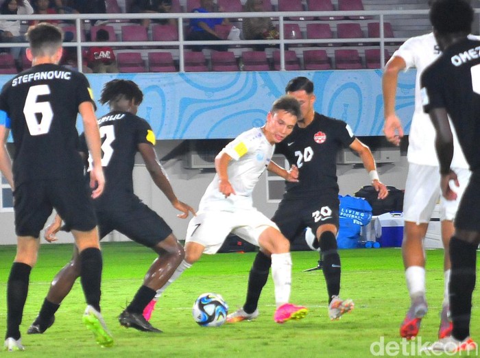 Kapten Uzbekistan, Lazizbek Mirzaev mendapat hadangan dari para pemain belakang Kanada.