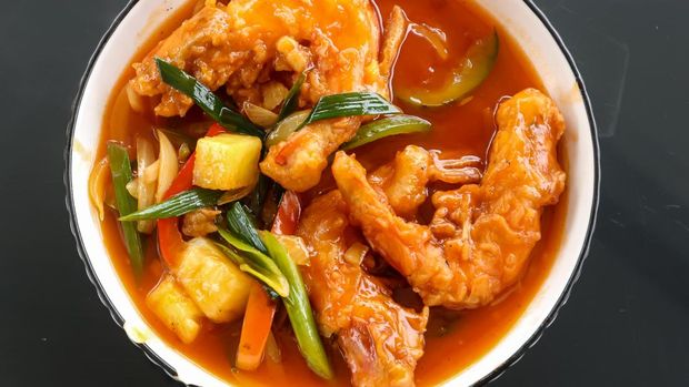 prawns in sweet and sour sauce on a white plate on the glass table. selective Focus