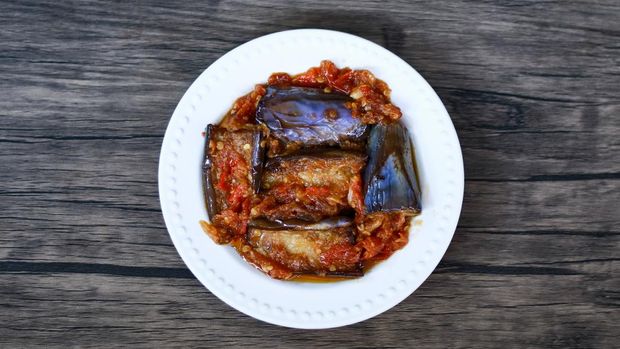 Terong balado (eggplants with chili sauce) on wood background. Indonesian cuisine from Padang, West Sumatra.