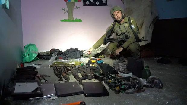 Israeli military spokesperson Rear Admiral Daniel Hagari shows what he says are weapons stored by Hamas in the basement of Rantissi Hospital, a paediatric hospital with a specialty in treating cancer patients, at a location given as Gaza, in this still image taken from video released November 13, 2023. Israel Defense Forces/Handout via REUTERS Acquire Licensing Rights