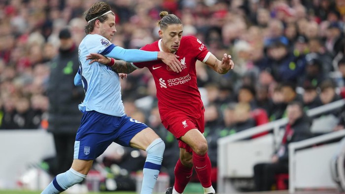 Brentfords Mathias Jensen, left, and Liverpools Kostas Tsimikas vie for the ball during the English Premier League soccer match between Liverpool and Brentford at Anfield stadium in Liverpool, England, Sunday, Nov. 12, 2023. (AP Photo/Jon Super)