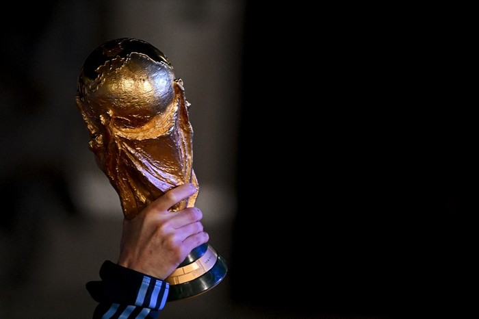 Argentina's captain and forward Lionel Messi holds the FIFA World Cup Trophy upon arrival at Ezeiza International Airport after winning the Qatar 2022 World Cup tournament in Ezeiza, Buenos Aires province, Argentina on December 20, 2022. (Photo by Luis ROBAYO / AFP)