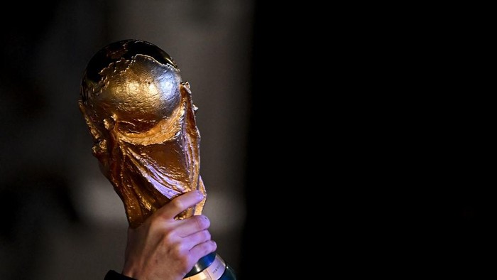 Argentinas captain and forward Lionel Messi holds the FIFA World Cup Trophy upon arrival at Ezeiza International Airport after winning the Qatar 2022 World Cup tournament in Ezeiza, Buenos Aires province, Argentina on December 20, 2022. (Photo by Luis ROBAYO / AFP)