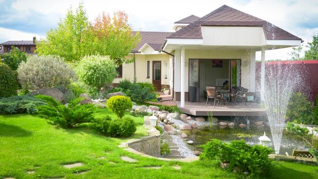 beautiful country house, garden with ornamental trees and plants, flat lawn and landscaping. Garden trees and evergreen conifers