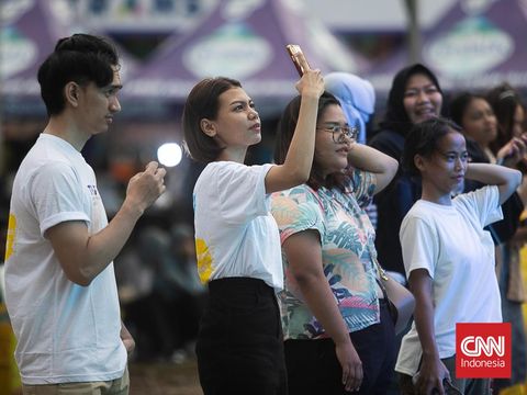 DJ Noraebang sukses membuat penggemar musik KPOP berkaraoke bersama meski diguyur hujan dalam acara THE FEST di Lapangan City Trans BSD, Sabtu (18/11). (CNN Indonesia/ Adi Ibrahim)