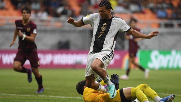 Penjaga gawang Timnas Jerman  Max Schmitt (kiri)  menerima operan bola dari rekannnya Almugera Kabar(tengah)  setelah berhasil merebut bola dari pemain   Venezuela Junior Colina (kanan)  dalam laga penyisihan Grup F Piala Dunia U-17 di Jakarta International Stadium, Jakarta, Sabtu (18/11/2023). ANTARA FOTO/Akbar Nugroho Gumay/nz