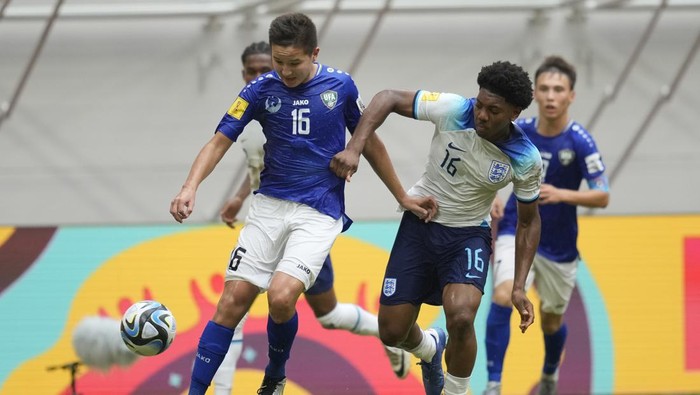 Uzbekistans Mukhamedali Reimov, left, battles for the ball against Englands Myles Lewis-Skelly during their FIFA U-17 World Cup round of 16 soccer match at Jakarta International Stadium in Jakarta, Indonesia, Wednesday, Nov. 22, 2023. (AP Photo/Dita Alangkara)