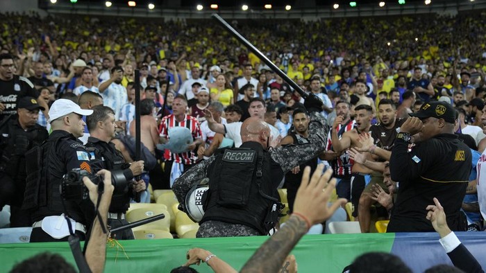 Police try to stop a fight between Brazilian and Argentinian fans prior to a qualifying soccer match for the FIFA World Cup 2026 at Maracana stadium in Rio de Janeiro, Brazil, Tuesday, Nov. 21, 2023.(AP Photo/Silvia Izquierdo)