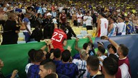 Emi Martinez bahkan memanjat pagar pembatas karena tidak terima melihat suporter Brasil kena pukul polisi. Ia diduga hendak merenggut tongkat pemukul dari tangan polisi. Foto: REUTERS/RICARDO MORAES