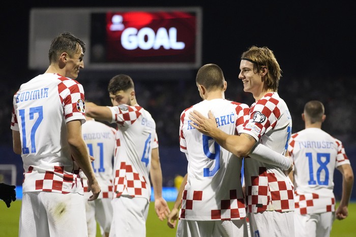 Croatias Ante Budimir, left, celebrates with his teammates after scoring against Armenia during the Euro 2024 group D qualifying soccer match between Croatia and Armenia at the Maksimir Stadium in Zagreb, Croatia, Tuesday, Nov. 21, 2023. (AP Photo/Darko Bandic)