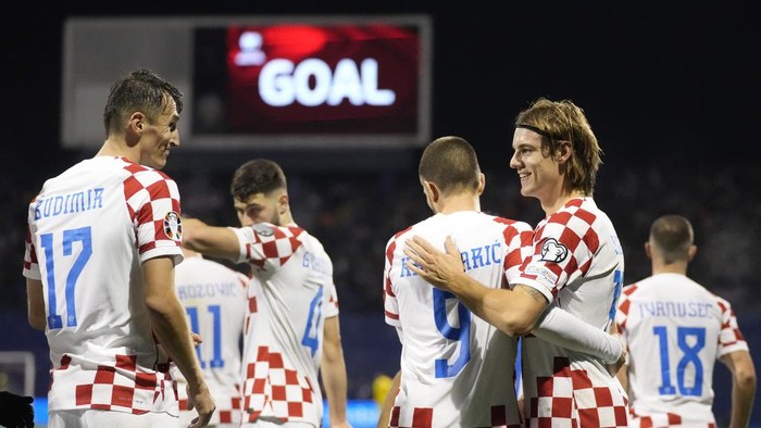 Croatias Ante Budimir, left, celebrates with his teammates after scoring against Armenia during the Euro 2024 group D qualifying soccer match between Croatia and Armenia at the Maksimir Stadium in Zagreb, Croatia, Tuesday, Nov. 21, 2023. (AP Photo/Darko Bandic)