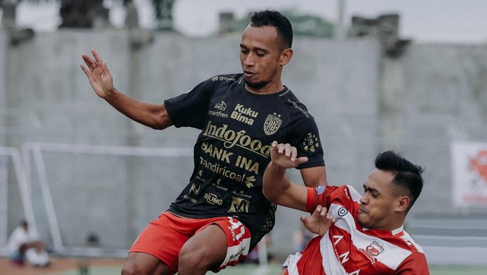 Penyerang Bali United Irfan Jaya (kiri) berduel dengan bek Madura United Novan Sasongko dalam laga Madura United vs Bali United di Gelora Bangkalan, Kamis (23/11/2023).