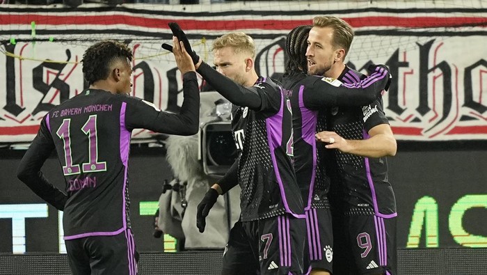 Bayerns Harry Kane, right, celebrates with his teammates after scoring his sides opening goal during the German Bundesliga soccer match between 1.FC Cologne and Bayern Munich in Cologne, Germany, Friday, Nov. 24, 2023. (AP Photo/Martin Meissner)