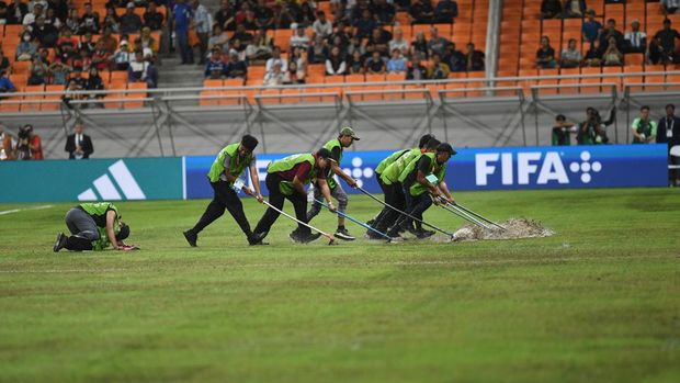 Petugas menyingkirkan air yang menggenangi lapangan akibat hujan menjelang pertandingan antara Timnas Argentina melawan Timnas Brasil pada perempat final Piala Dunia U-17 2023 di Jakarta International Stadium, Jakarta, Jumat (24/11/2023). ANTARA FOTO/Aditya Pradana Putra/tom.