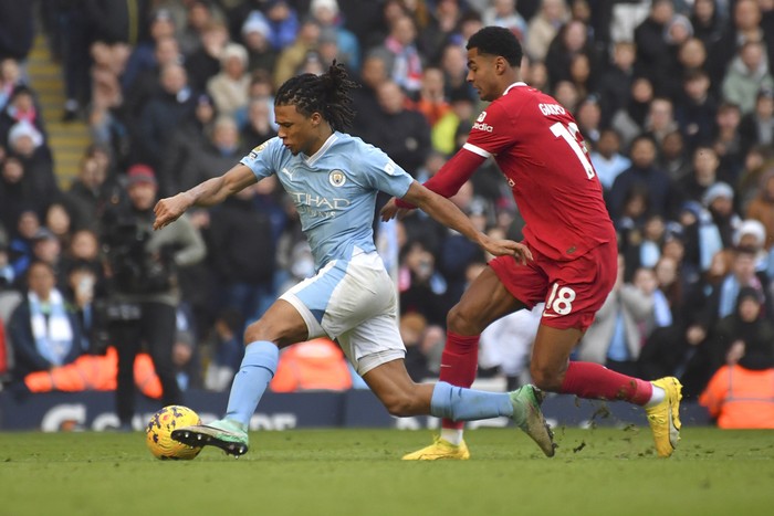 Manchester Citys Nathan Ake, left, challenges for the ball with Liverpools Cody Gakpo during the English Premier League soccer match between Manchester City and Liverpool at Etihad stadium in Manchester, England, Saturday, Nov. 25, 2023. (AP Photo/Rui Vieira)