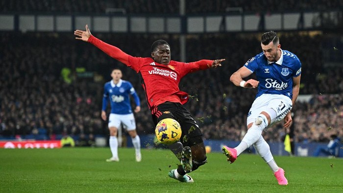 Manchester Uniteds English midfielder #37 Kobbie Mainoo (L) fights for the ball with Evertons English striker #11 Jack Harrison during the English Premier League football match between Everton and Manchester United at Goodison Park in Liverpool, north west England on November 26, 2023. (Photo by Paul ELLIS / AFP) / RESTRICTED TO EDITORIAL USE. No use with unauthorized audio, video, data, fixture lists, club/league logos or live services. Online in-match use limited to 120 images. An additional 40 images may be used in extra time. No video emulation. Social media in-match use limited to 120 images. An additional 40 images may be used in extra time. No use in betting publications, games or single club/league/player publications. /