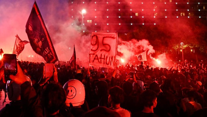 Sejumlah pendukung tim sepak bola Persija menyanyikan yel-yel dan menyalakan api suar di kawasan Bundaran HI, Jakarta, Selasa (28/11/2023). Ribuan pendukung berjuluk Jakmania terseut berkumpul untuk merayakan hari ulang tahun tim sepak bola Persija Jakarta yang ke-95 tahun. ANTARA FOTO/Sulthony Hasanuddin/aww.