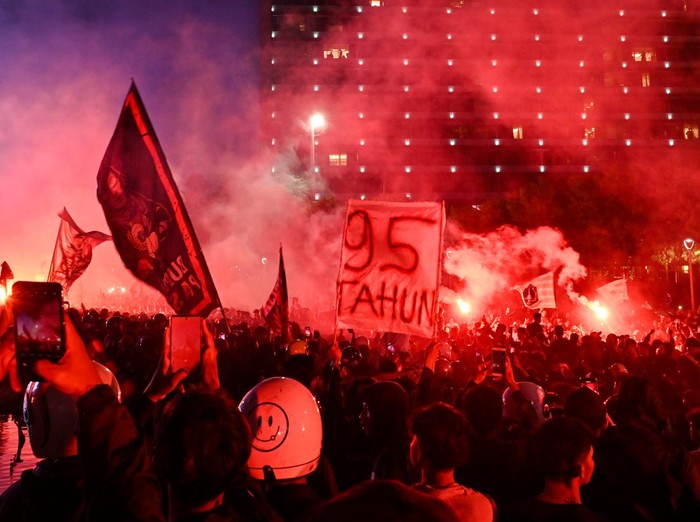 Sejumlah pendukung tim sepak bola Persija menyanyikan yel-yel dan menyalakan api suar di kawasan Bundaran HI, Jakarta, Selasa (28/11/2023). Ribuan pendukung berjuluk Jakmania terseut berkumpul untuk merayakan hari ulang tahun tim sepak bola Persija Jakarta yang ke-95 tahun. ANTARA FOTO/Sulthony Hasanuddin/aww.