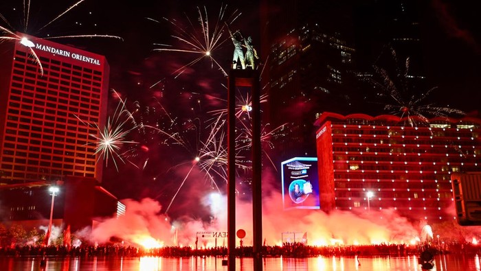 Sejumlah pendukung tim sepak bola Persija menyanyikan yel-yel dan menyalakan api suar di kawasan Bundaran HI, Jakarta, Selasa (28/11/2023). Ribuan pendukung berjuluk Jakmania terseut berkumpul untuk merayakan hari ulang tahun tim sepak bola Persija Jakarta yang ke-95 tahun. ANTARA FOTO/Sulthony Hasanuddin/aww.