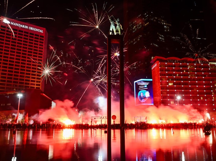 Sejumlah pendukung tim sepak bola Persija menyanyikan yel-yel dan menyalakan api suar di kawasan Bundaran HI, Jakarta, Selasa (28/11/2023). Ribuan pendukung berjuluk Jakmania terseut berkumpul untuk merayakan hari ulang tahun tim sepak bola Persija Jakarta yang ke-95 tahun. ANTARA FOTO/Sulthony Hasanuddin/aww.