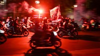 Sejumlah pendukung Persija menyanyikan yel-yel dan menyalakan suar di kawasan Bundaran HI, Jakarta, Selasa (28/11/2023). 