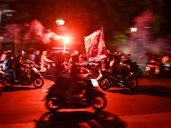 Sejumlah pendukung Persija menyanyikan yel-yel dan menyalakan suar di kawasan Bundaran HI, Jakarta, Selasa (28/11/2023). 
