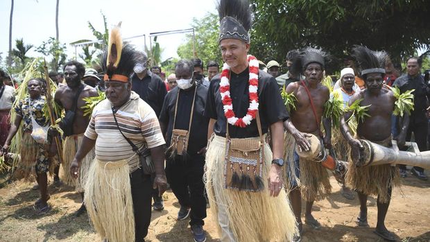 Calon presiden nomor urut tiga Ganjar Pranowo (ketiga kanan) berjalan dengan Kepala Kampung Wendu Matara Kalimus Mahuse (kiri) saat melakukan kampanye perdana di Distrik Semangga, Merauke, Papua Selatan, Selasa (28/11/2023). Dalam tatap muka itu, Ganjar Pranowo menemui warga dusun Waninggap Nango, Matara dan Urumb dengan mencanangkan program satu desa satu puskesmas. ANTARA FOTO/M Risyal Hidayat