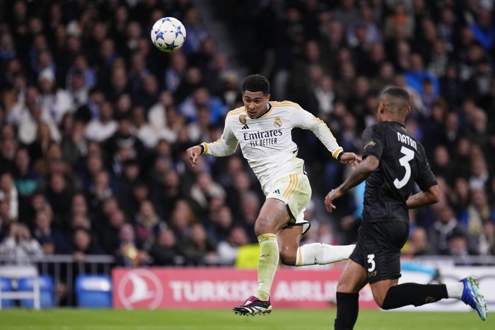 Real Madrid's Jude Bellingham, left, scores his side's second goal as Napoli's Natan challenges during the Champions League Group C soccer match between Real Madrid and Napoli at the Santiago Bernabeu stadium in Madrid, Spain, Wednesday, Nov. 29, 2023. (AP Photo/Manu Fernandez)