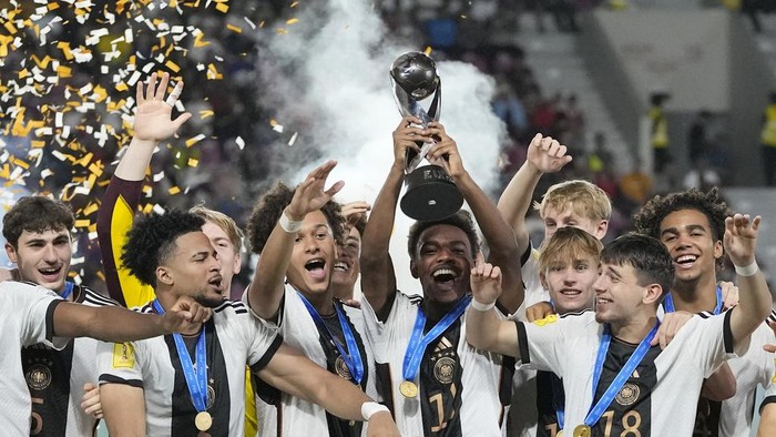 Team Germany celebrates on the podium with their trophy after their victory over France in the U-17 World Cup final soccer match at Manahan Stadium in Surakarta, Indonesia, Saturday, Dec. 2, 2023. (AP Photo/Achmad Ibrahim)