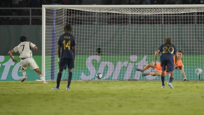 Germanys Paris Brunner, left, scores a goal through a penalty kick as France goalkeeper Paul Argney reacts during their U-17 World Cup final soccer match at Manahan Stadium in Surakarta, Indonesia, Saturday, Dec. 2, 2023. (AP Photo/Achmad Ibrahim)