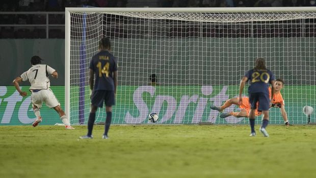 Germany's Paris Brunner, left, scores a goal through a penalty kick as France' goalkeeper Paul Argney reacts during their U-17 World Cup final soccer match at Manahan Stadium in Surakarta, Indonesia, Saturday, Dec. 2, 2023. (AP Photo/Achmad Ibrahim)