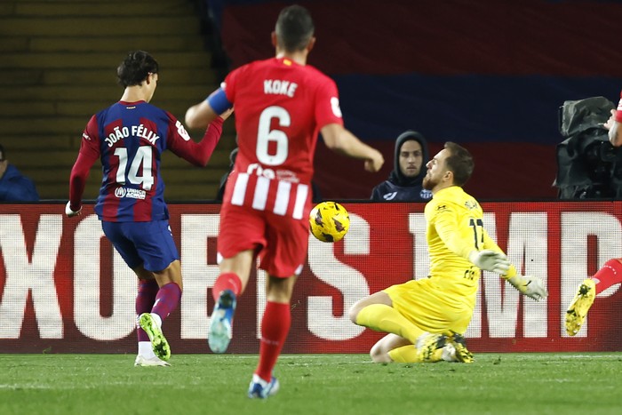 Barcelonas Joao Felix, left, scores the opening goal past Atletico Madrids goalkeeper Jan Oblak during the Spanish La Liga soccer match between Barcelona and Atletico Madrid at the Olimpic Lluis Companys stadium in Barcelona, Spain, Sunday, Dec. 3, 2023. (AP Photo/Joan Monfort)