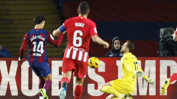 Barcelonas Joao Felix, left, scores the opening goal past Atletico Madrids goalkeeper Jan Oblak during the Spanish La Liga soccer match between Barcelona and Atletico Madrid at the Olimpic Lluis Companys stadium in Barcelona, Spain, Sunday, Dec. 3, 2023. (AP Photo/Joan Monfort)