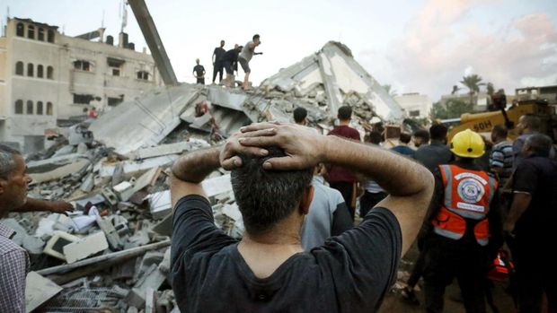 EDITORS NOTE: Graphic content / A man reacts as he watches recuers and civilians remove the rubble of a home destroyed following an Israeli attack on the town of Deir Al-Balah, in the central Gaza Strip, on October 15, 2023, amid the ongoing battles between Israel and the Palestinian Islamist group Hamas. Thousands of Palestinians have gathered in the south of the Gaza Strip, laying out beds on the streets after UN-run schools filled up following Israel's warning to evacuate the north of the impoverished enclave. (Photo by AFP)